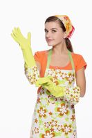 woman-in-apron-putting-on-rubber-glove_1844718